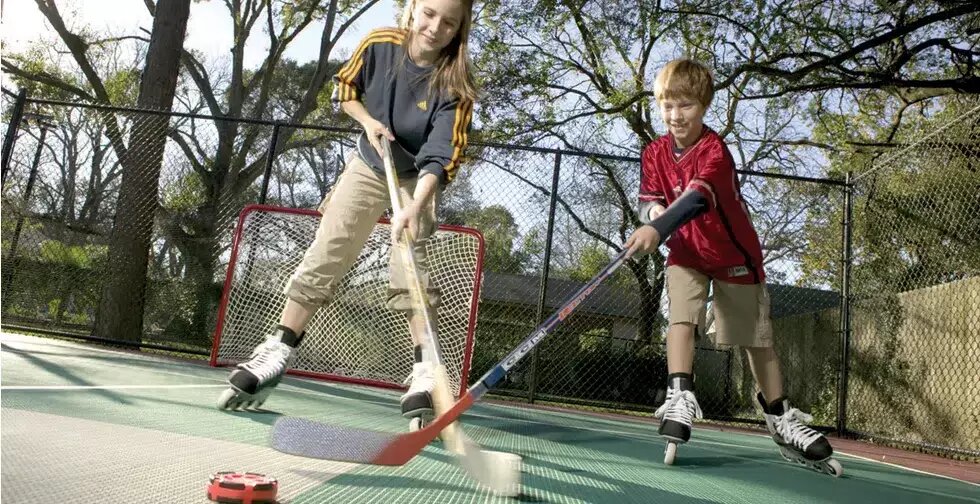 Kids playing hockey on a backyard rink surface