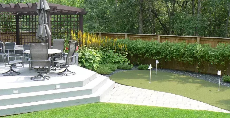Synthetic putting green beside a stone patio