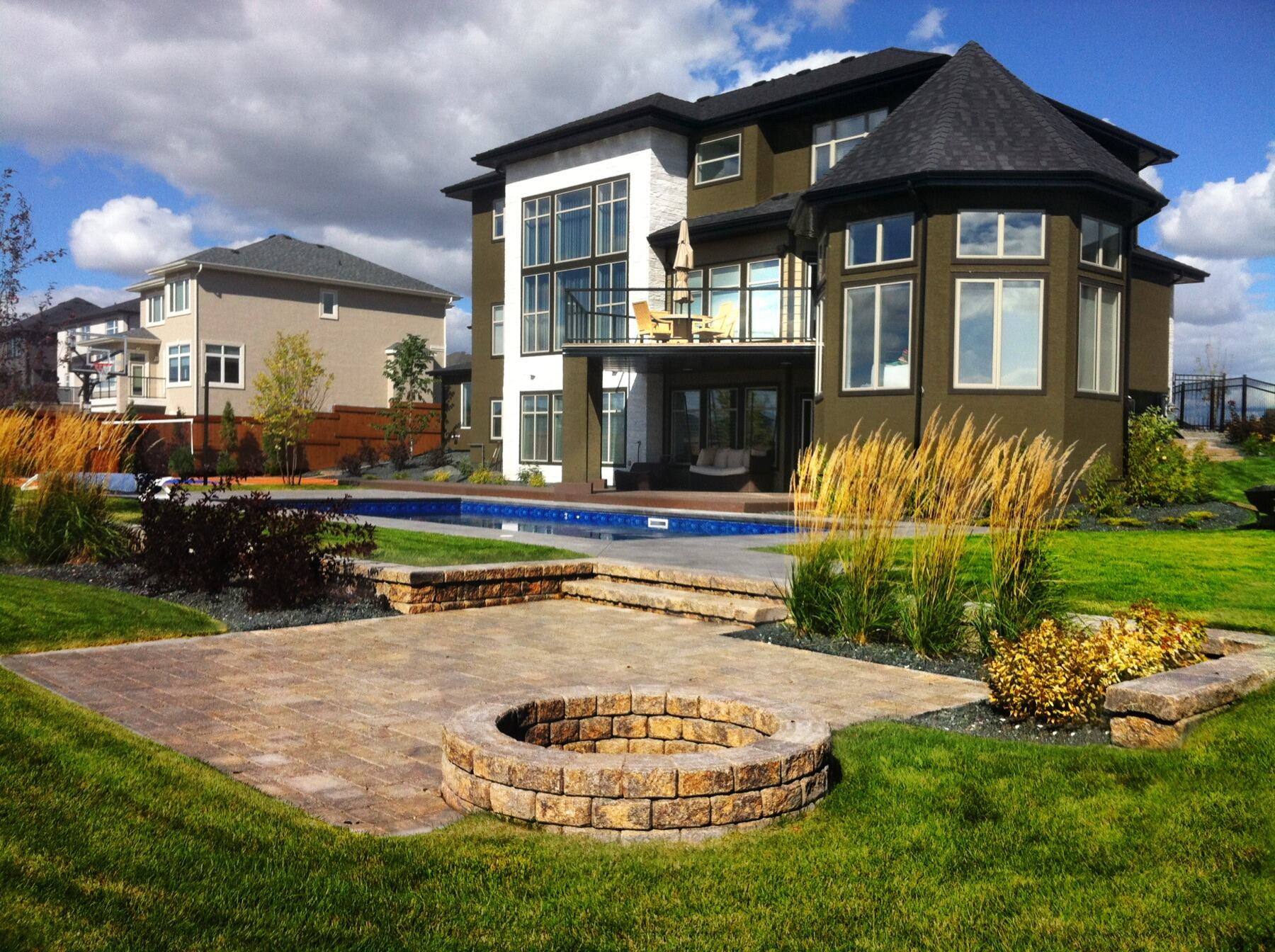 Stone fire pit terrace behind a modern home