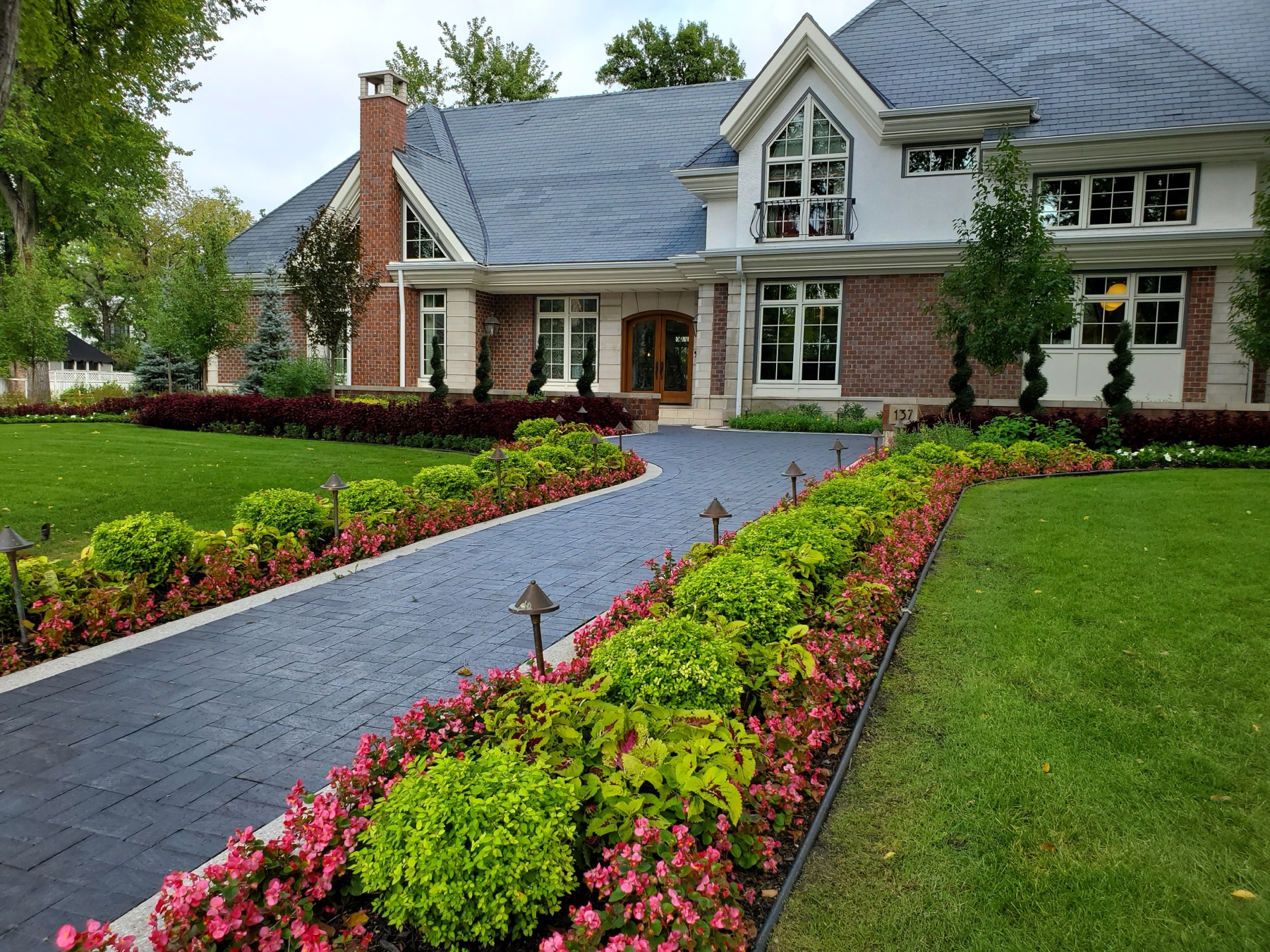 Formal driveway lined with boxwood and flower borders