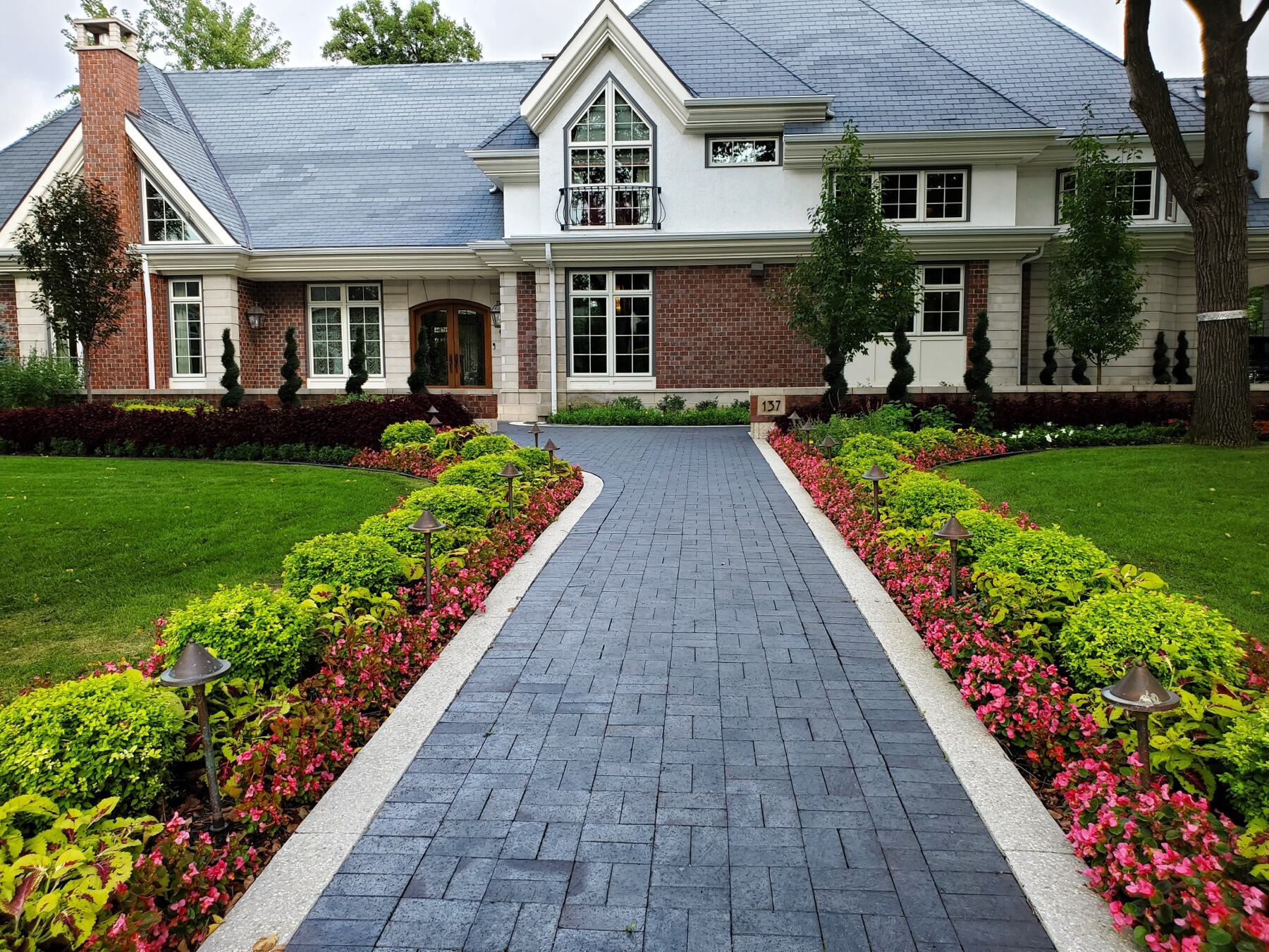 Formal paver walkway lined with gardens