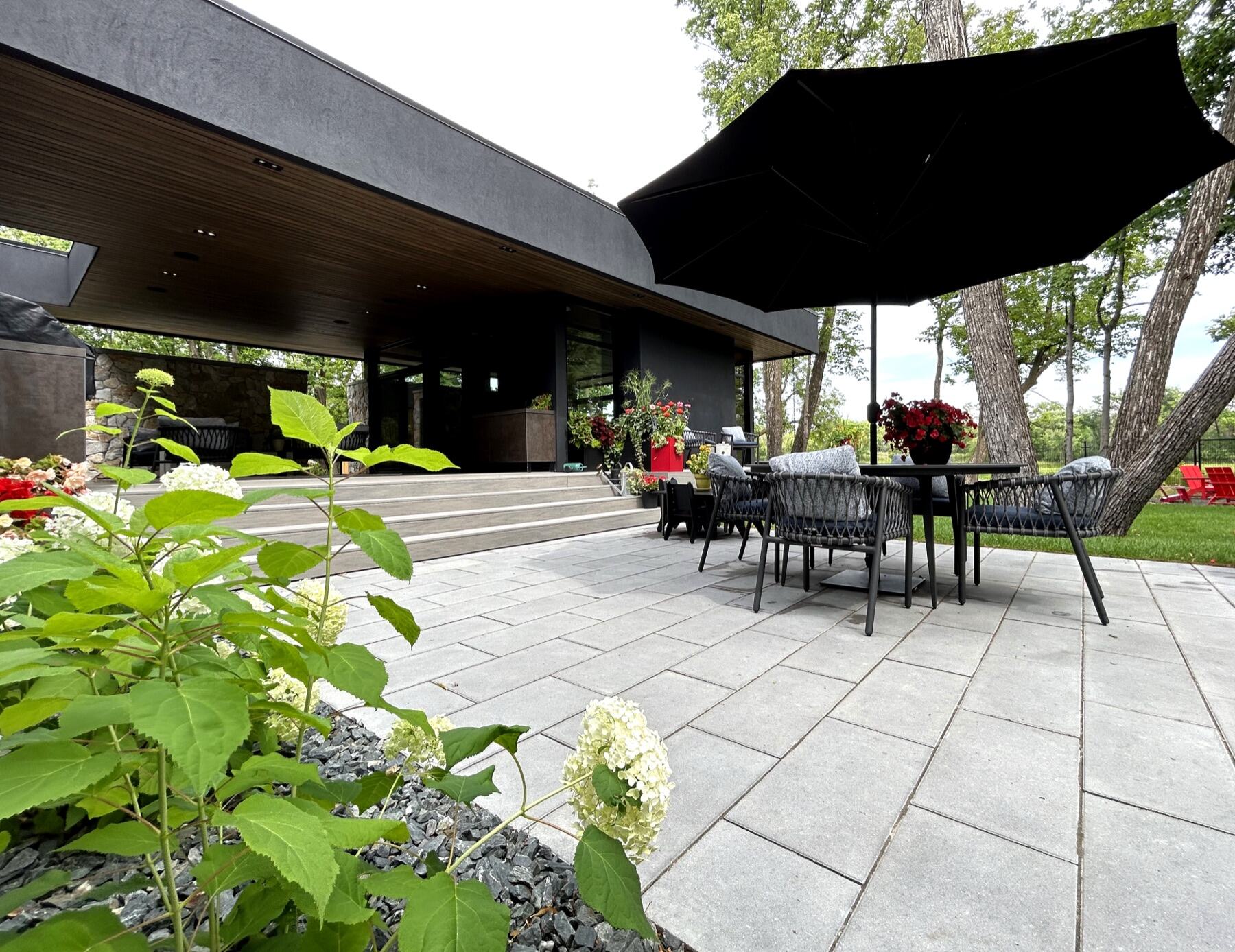 Modern patio with black umbrella and layered plantings