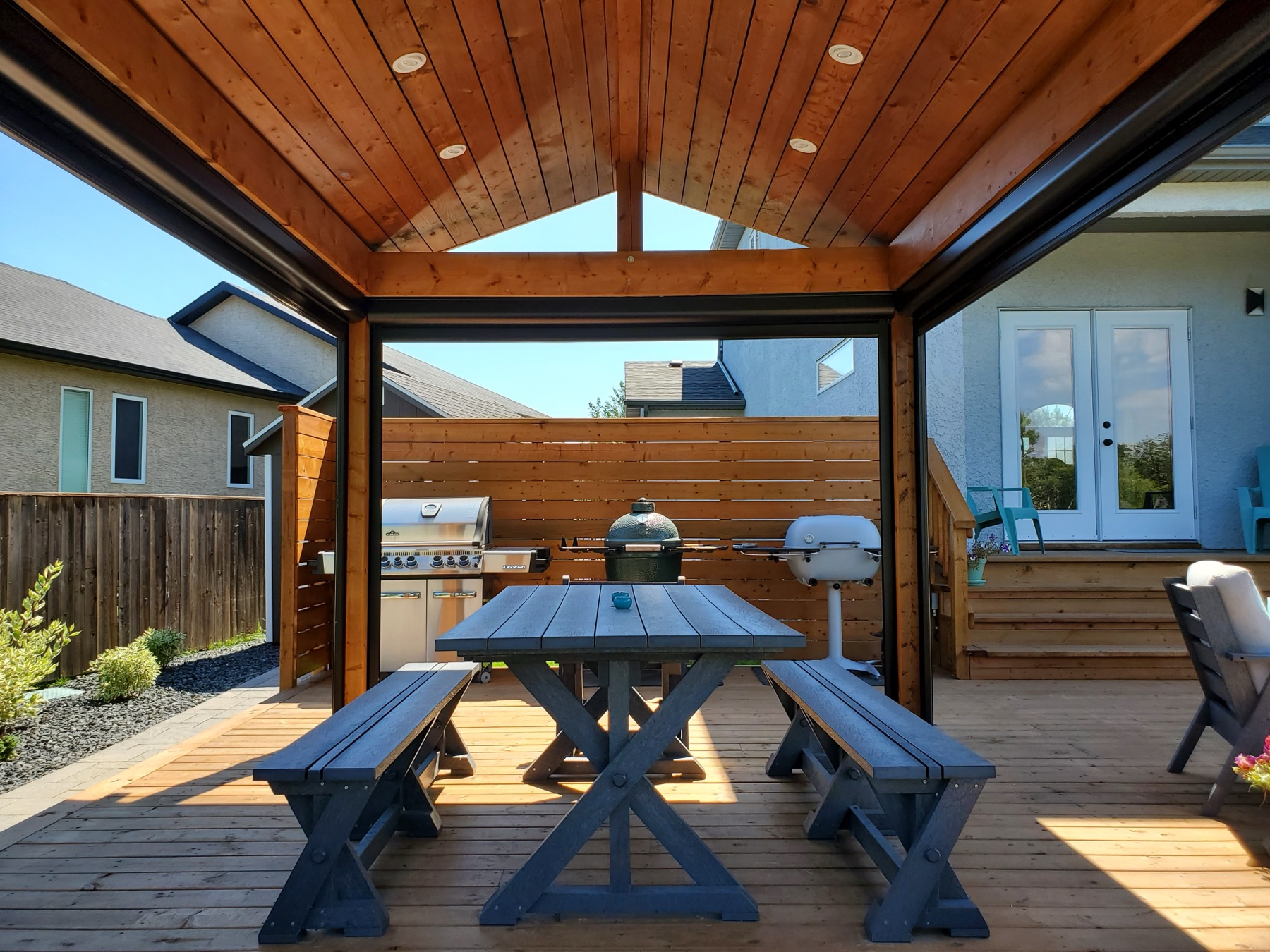 Covered outdoor kitchen and dining pavilion on a cedar deck
