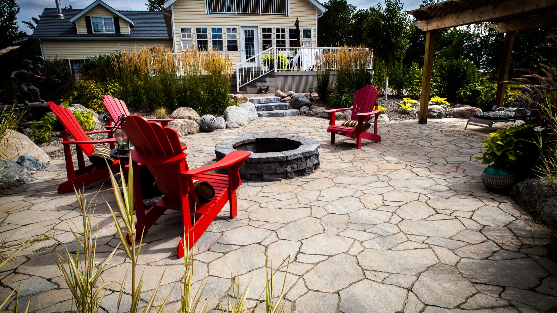 Flagstone fire pit with red Adirondack chairs